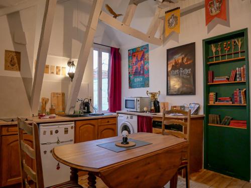 - une cuisine avec une table, une cuisinière et un évier dans l'établissement La tanière du sorcier, à Saumur