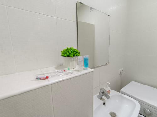 a white bathroom with a sink and a mirror at ЖК Времена года Весна Кабанбай Батыра 46 in Taldykolʼ