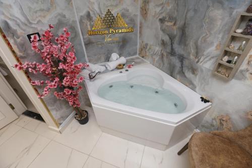 a bath tub in a bathroom with a christmas sign at Horizon Pyramids View inn in Cairo