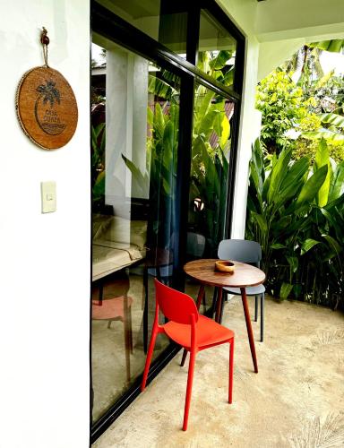 a red chair and a table on a patio at Casa Basa Siargao in General Luna