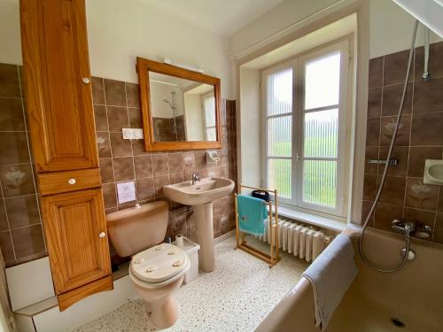 une salle de bain avec un lavabo, des toilettes et une baignoire dans l'établissement Maison entre campagne et mer, à Lanvellec
