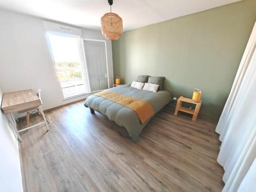 une chambre avec un lit et une grande fenêtre dans l'établissement Agréable appartement lumineux avec grande terrasse, à La Rochelle