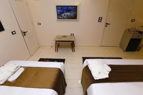 a room with two beds and a table in it at Horizon Pyramids View inn in Cairo