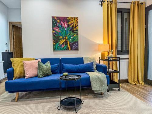 a living room with a blue couch and a table at Le Bleuet Tout confort in La Soukra