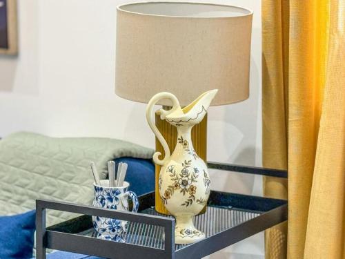 a vase sitting on a table next to a lamp at Le Bleuet Tout confort in La Soukra