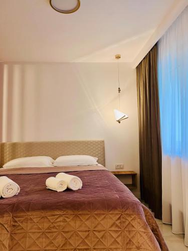 ein Schlafzimmer mit einem Bett, auf dem zwei Handtücher liegen in der Unterkunft IMPERIUM DK STUDIO in Giurgiu