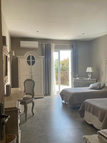 une chambre avec deux lits et un bureau et une fenêtre dans l'établissement VILLA luxueuse privée avec piscine lagon, à Calenzana