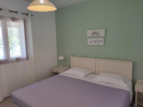 a bedroom with a bed and a window at Limenaria Apartments in Mochlos