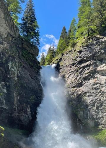 a waterfall on the side of a rocky cliff at I Larici - Appartamento per sognare in Alpe Devero