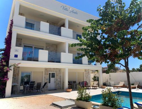 a villa with a swimming pool in front of it at Apartments Chico in Sveti Filip i Jakov