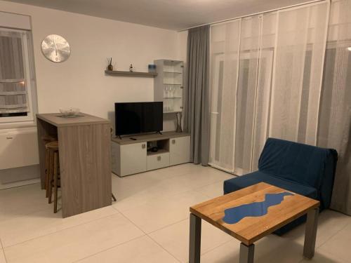 a living room with a blue chair and a television at Apartments Chico in Sveti Filip i Jakov
