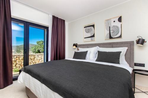 a bedroom with a large bed and a large window at Villa Mare in Vinišće
