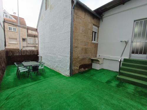 a patio with green flooring and a table and chairs at Casa Miguel in Teis