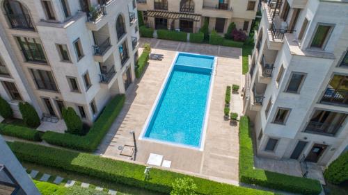 サニービーチにあるАпарткомплекс Амара Слънчев Бряг Студио 13の2棟の建物の間にあるスイミングプールのオーバーヘッドビュー