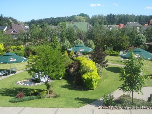 una vista aerea su un giardino con ombrelloni e cespugli di Zajazd Skalny a Ostrów Mazowiecka