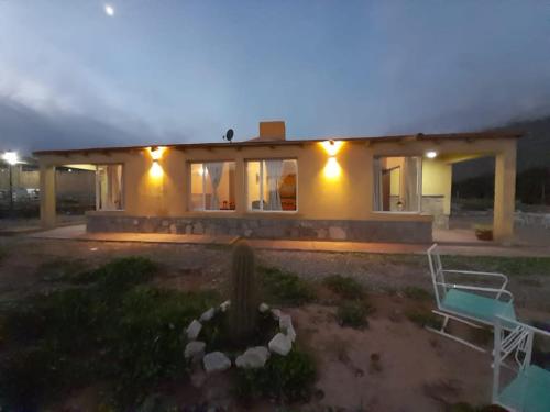 a house with a bench in front of it at night at 4 ELEMENTOS in Huacalera