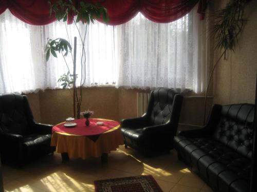 a living room with black leather chairs and a table at Zajazd Skalny in Ostrów Mazowiecka