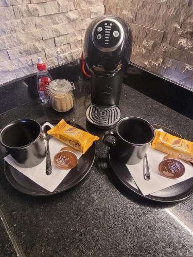 una macchinetta del caffè e due tazze su un bancone di Morumbi, Apartamento Pub, SPA com hidromassagem, PISCINA Aquecida PRIVATIVA, LAREIRA, tudo que você precisa para descansar, trabalhar ou realizar aquela comemoração! Com total conforto e PRIVACIDADE! O Apt Nota 10 de SP! a San Paolo