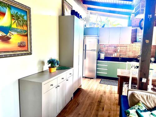 a kitchen with white cabinets and a refrigerator at RECANTO DOS PASSARINHOS LINDA CASA COM 2 quartos in Balneário Camboriú