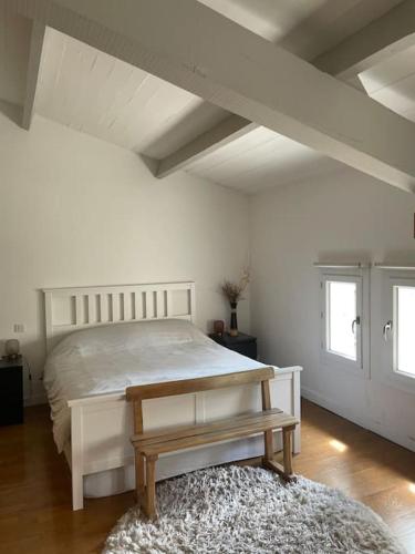 - une chambre blanche avec un lit et un banc dans l'établissement villa en provence avec piscine, aux Angles (Gard)