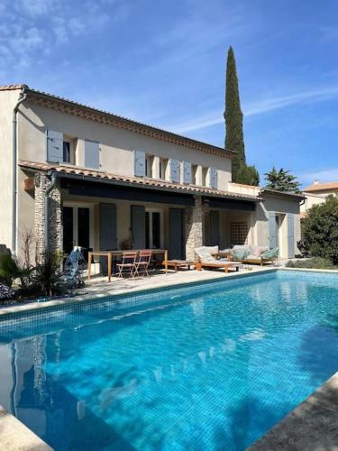 une grande piscine devant une maison dans l'établissement villa en provence avec piscine, aux Angles (Gard)