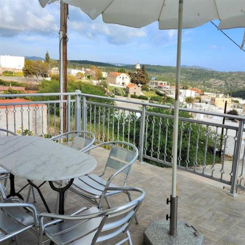 a table and chairs on a balcony with an umbrella at Bellavista House in Monolithos Rhodes in Monólithos