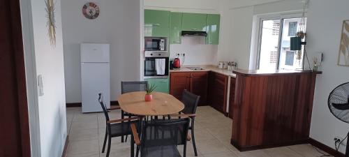 a kitchen with a table and chairs in a room at Appartement NANA A 34 - Appartement Cosy et Lumineux - Vue Panoramique- Centre ville- - Cuisine équipée- CLIM- WIFI - NETFLIX-Parking Public Gratuit-Garage privé payant in Cayenne