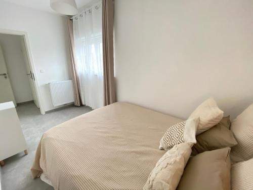 a bedroom with a bed with a pillow on it at Appartement 2 chambres confort 4-5 personnes in Chapelle-lez-Herlaimont