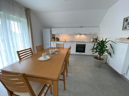 a kitchen and dining room with a wooden table and chairs at Appartement 2 chambres confort 4-5 personnes in Chapelle-lez-Herlaimont