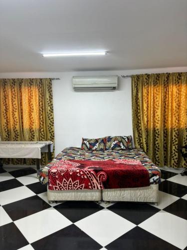 a bedroom with a bed and a checkered floor at LARGE M BEDROOM Attached Bathroom with Terrace Access in a villa Sharjah in Sharjah