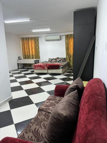 a living room with a couch and a checkered floor at LARGE M BEDROOM Attached Bathroom with Terrace Access in a villa Sharjah in Sharjah