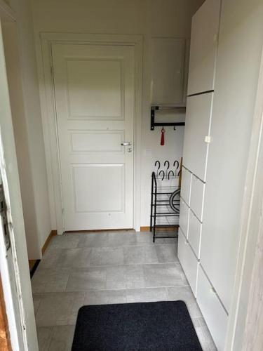a hallway with a white door and a tile floor at Stuga i Borlänge in Borlänge