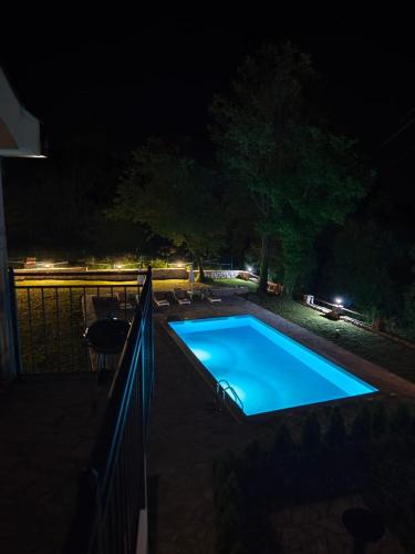een zwembad dat 's nachts verlicht is bij Stanovcic Apartments in Herceg-Novi