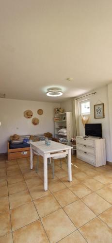 un salon avec une table au milieu d'une pièce dans l'établissement Charmante Maisonnette, Piscine, Jardin, Parking, à Argelès-sur-Mer