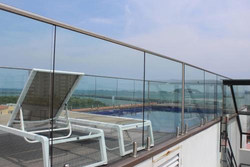 a chair on the balcony of a building with a pool at Departamento en Casco Antiguo in Panama City