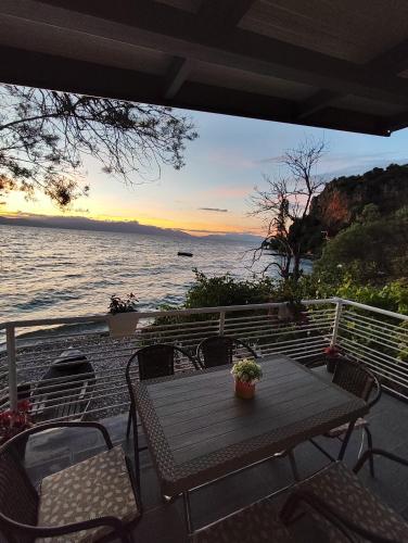 a table and chairs on a deck with a view of the ocean at Apartment DULE Trpejca in Ohrid
