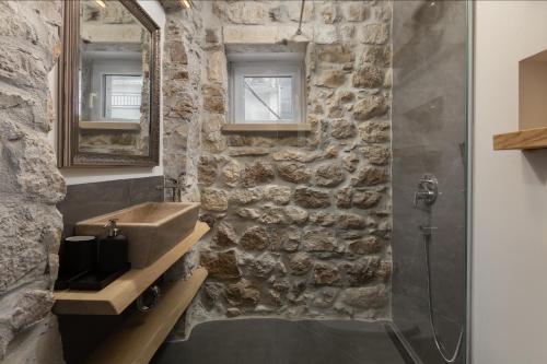 a stone bathroom with a sink and a shower at NEW - Casa Columba - 4 Star Design Boutique Hotel with Outdoor Pool & Private Garden in Makarska