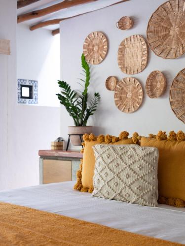 a bed with a yellow pillow and plates on the wall at La Paranera Hotel & Relax in Comala