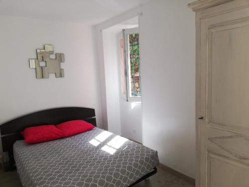 - une chambre avec un lit et un oreiller rouge dans l'établissement Appartement 2 pièces cosy, à Grasse