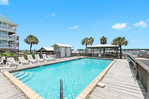 a large swimming pool with chairs and a gazebo at 3BR Condo Gulf Views with Pool, Boat Launch and Dock in Gulf Shores