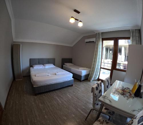a hotel room with two beds and a table and a window at Elite Hotel Kobuleti in K'obulet'i