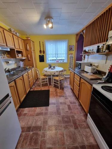 a kitchen with wooden cabinets and a table in it at Appartement indépendant rez-de-chaussée in Saint-Pierre