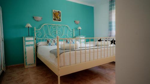 a bedroom with two beds and a blue wall at La Casa de Mima in Cubelles