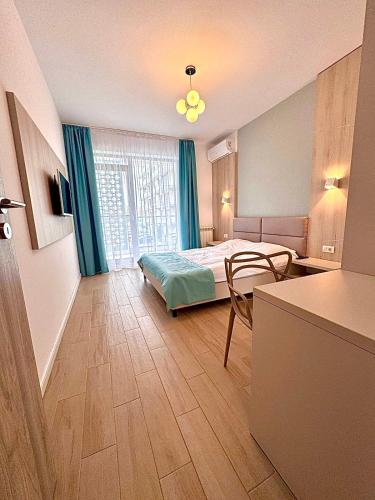 a bedroom with a bed and a desk and a table at Summerland Seaview Apartments in Mamaia