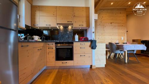 a large kitchen with wooden cabinets and a table at Moo-ntain Suite by Villars Luxury in Villars-sur-Ollon