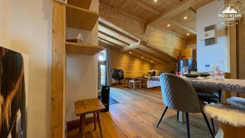 a kitchen and living room with wooden ceilings and a table at Moo-ntain Suite by Villars Luxury in Villars-sur-Ollon