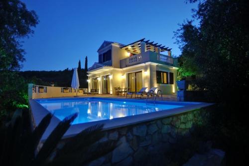 a house with a swimming pool in front of a house at Triena Quality Villas in Gaios