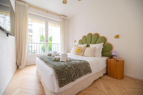 une chambre avec un grand lit et une grande fenêtre dans l'établissement Luxury Flat Eiffel Tower View, à Paris