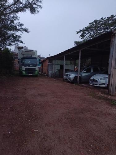 a truck parked in a garage next to two cars at New hotel in Alegrete