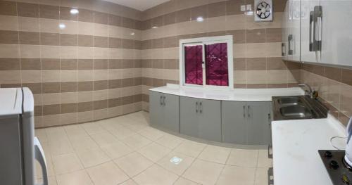 a kitchen with a sink and a window at المنام بارك للشقق المخدومة in Khamis Mushayt
